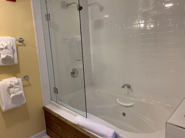 A clean bathroom featuring a glass-enclosed shower and a spacious bathtub.