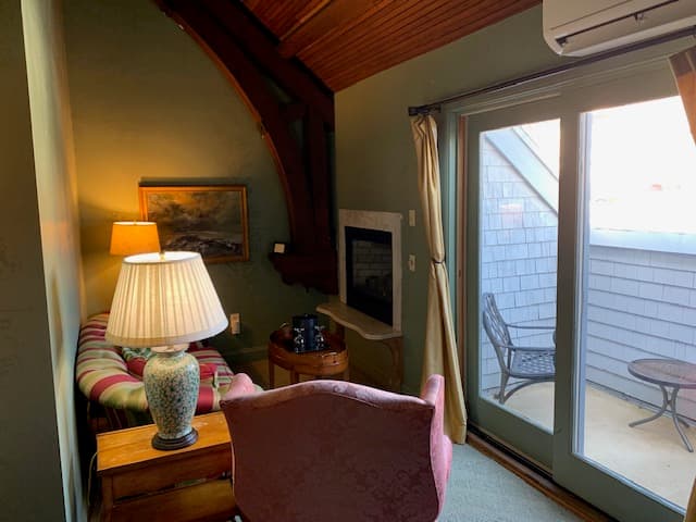 Cozy sitting area featuring a lamp, a painting, and a view of a patio through glass doors.