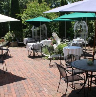 Outdoor tables and chairs are set at lunch
