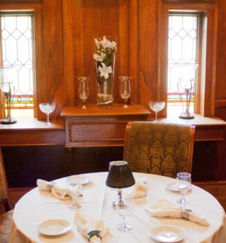 An intimate table for 2 is set in front of stained glass