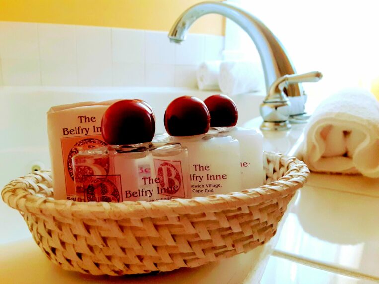 A basket of bath amenities sits on the edge of a tub