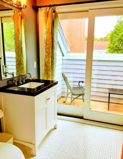 A bathroom is shown with a small balcony attached