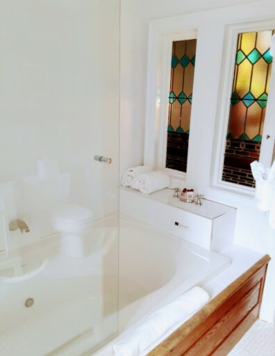 A jacuzzi is shown with stained glass at the foot of it