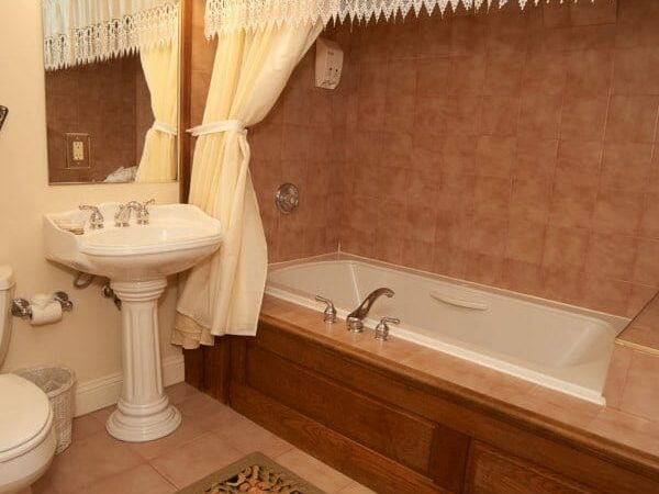 A lovely Jacuzzi tub is shown with brown tiles