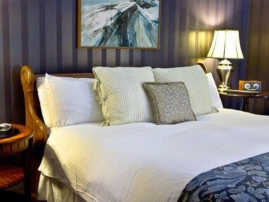 A madeup bed is pictured with a blue comforter
