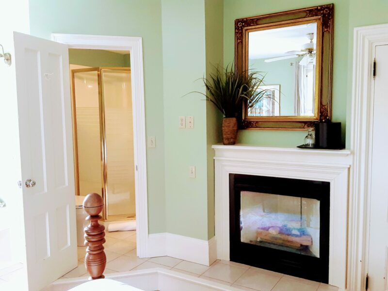 A lovely room with gas fireplace stove and a mirror over it