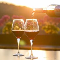 2 wine glasses are shown at sunset